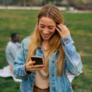 A girl laughs and uses a smartphone